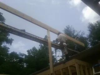 Carpenter setting a ridge beam over a new addition frame — Ice Dam Removal by Roofing Brothers in Spotsylvania