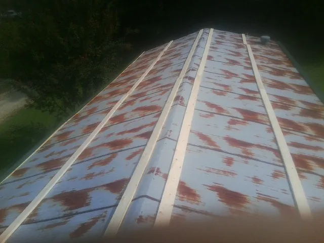 Rusted metal roof panels with new wood purlins before replacement — Storm Damage Roof Repair in Spotsylvania by Roofing Brothers