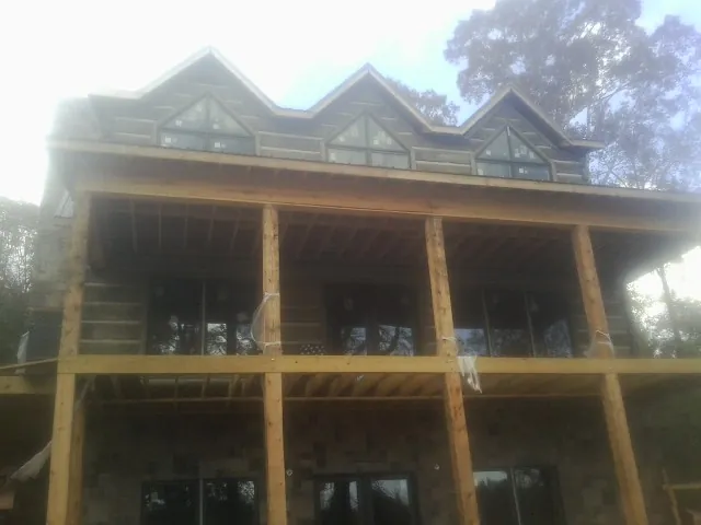 Dormers and porch framing on a large log home under construction — Roof Coating work by our crew in Spotsylvania